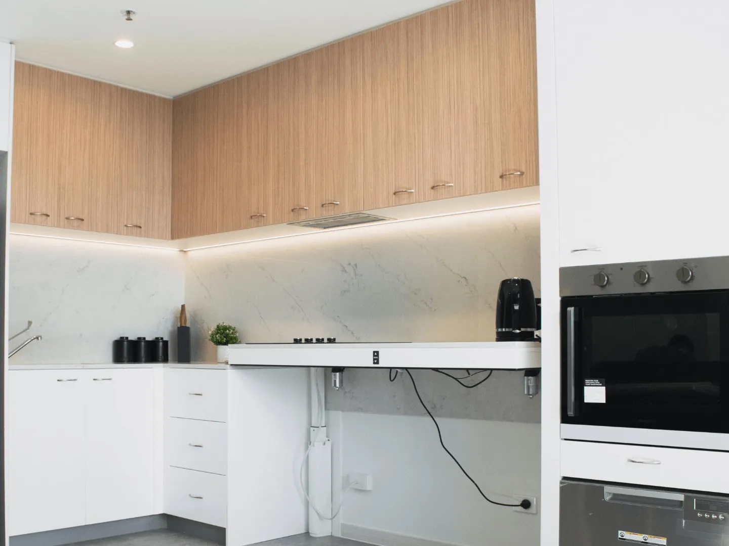 an accessible kitchen with a height adjustable bench and a wall oven