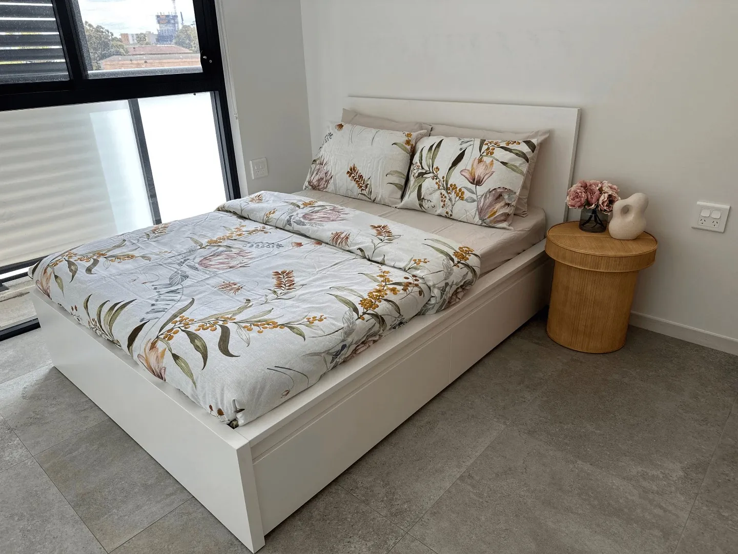a bedroom with a double bed, bedside table and a window looking out over Liverpool