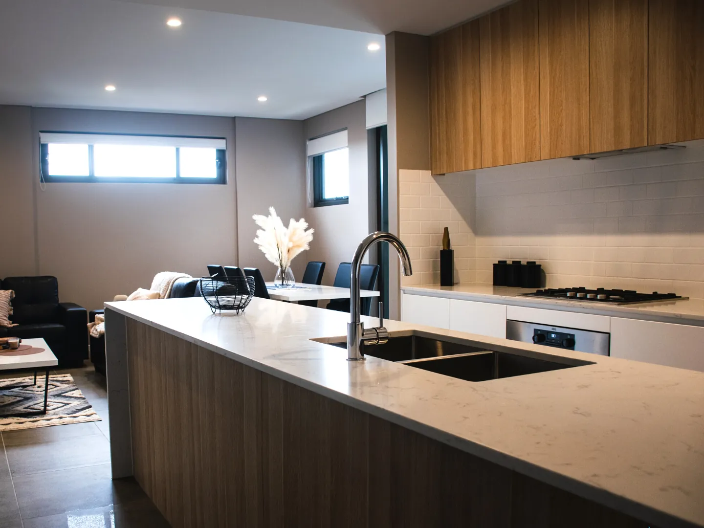 an open plan living and dining space with a kitchen island bench