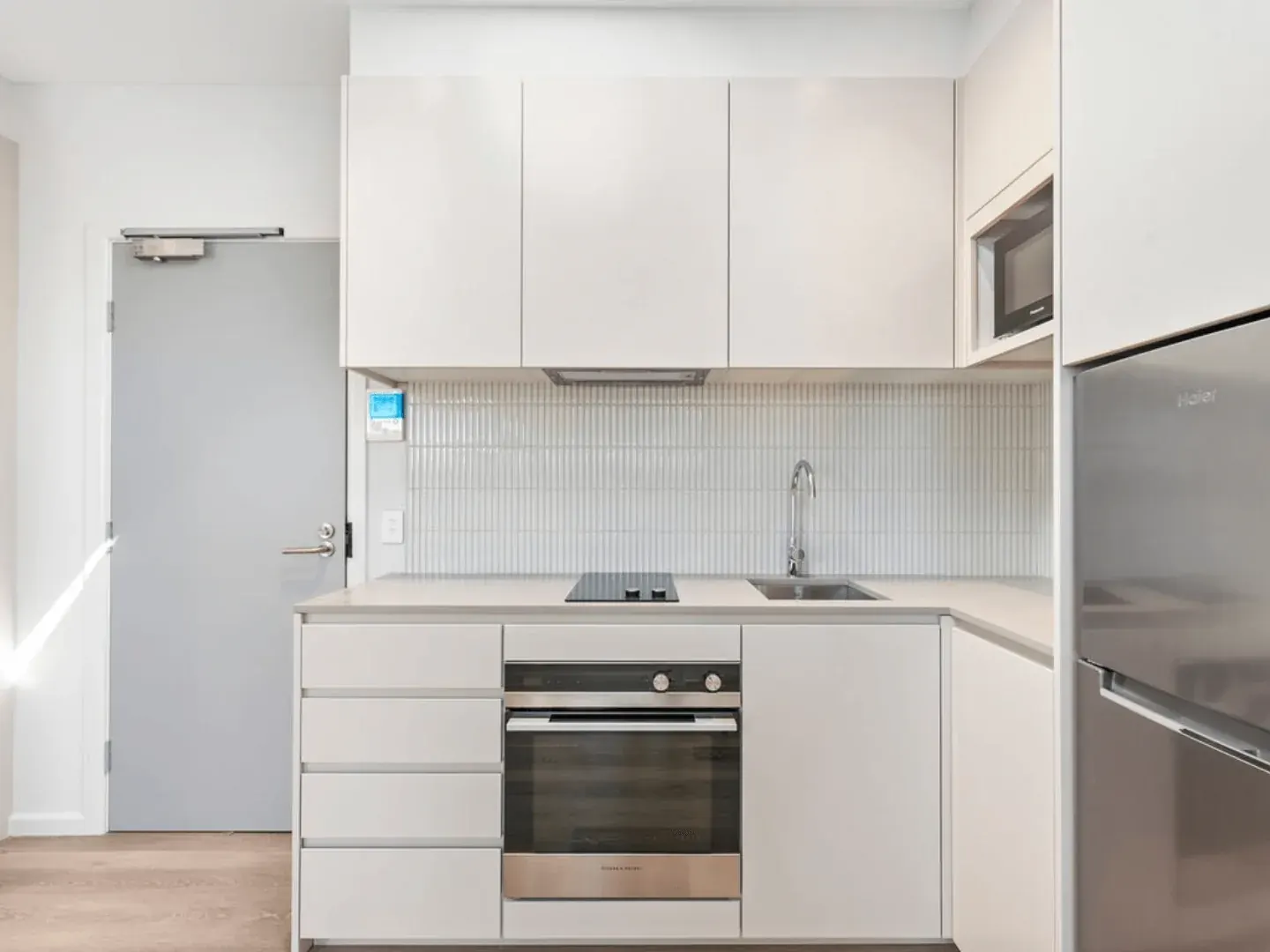 the kitchen in a studio apartment at Erskineville, with an oven, cooktop and fridge