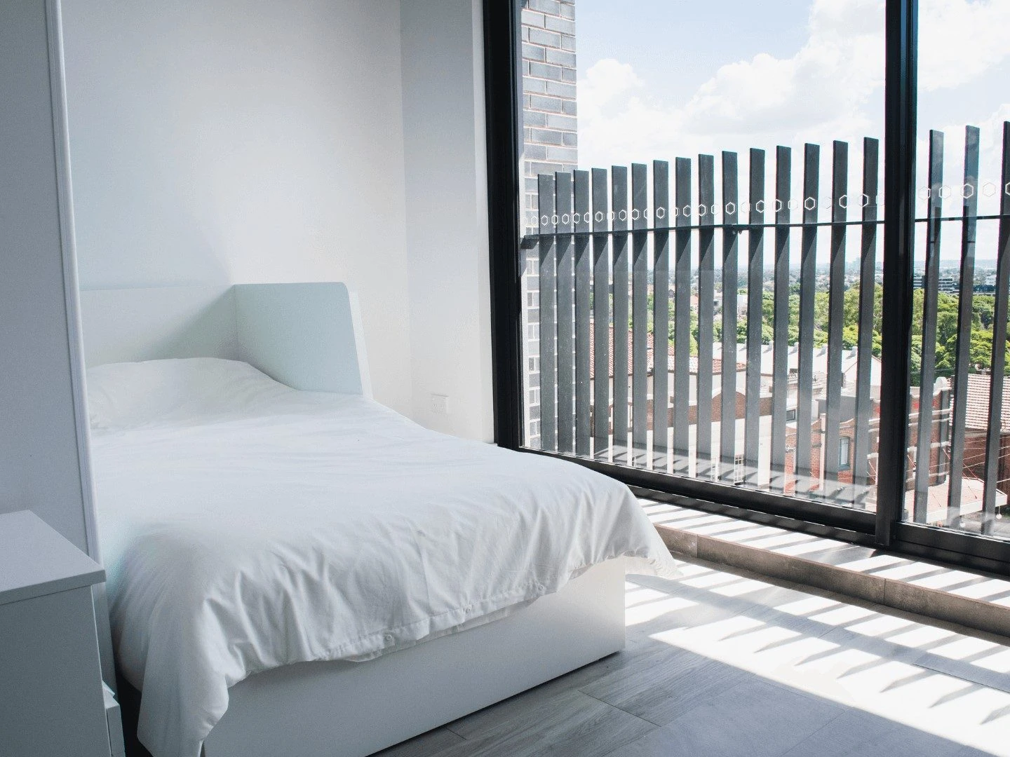 a studio bedroom at Petersham with a window looking over the rooftops