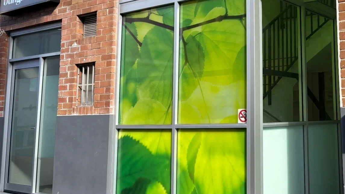 the Bell Lane entrance to the Randwick village, a brick building with a tall green leaf artwork beside the entry door