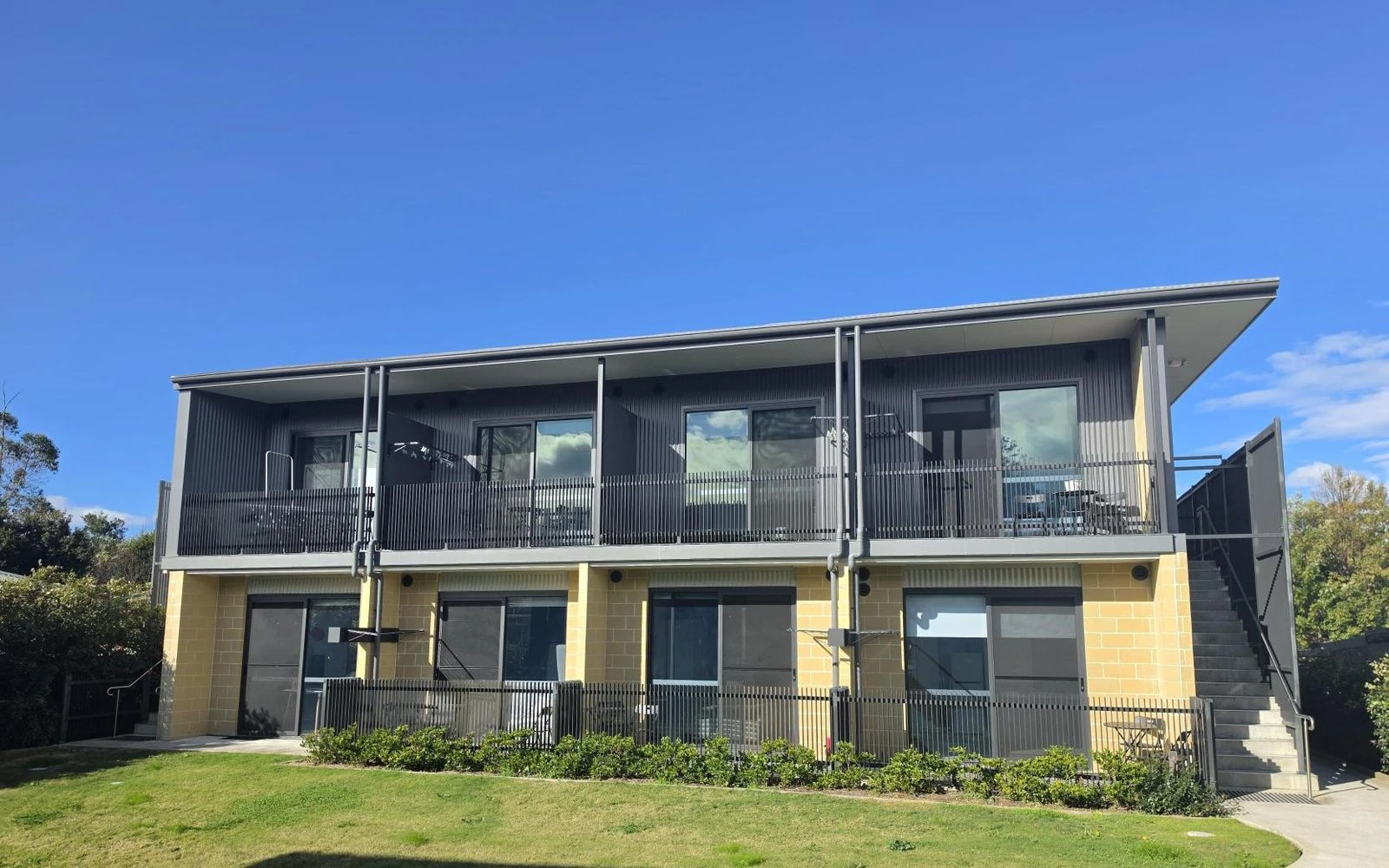 The Wyong Vertical Village building, with balconies and landscaped entry.